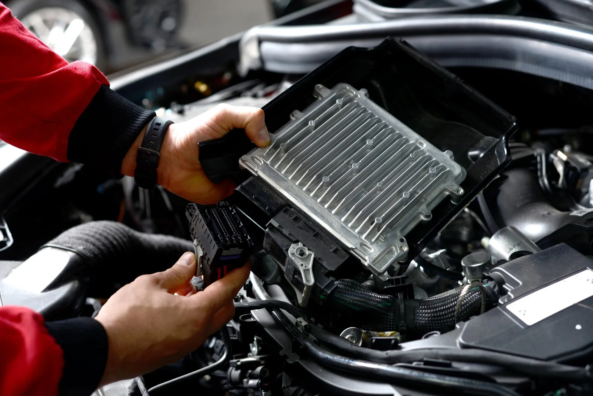 Mechanik trzymający sterownik silnika nad komorą silnika